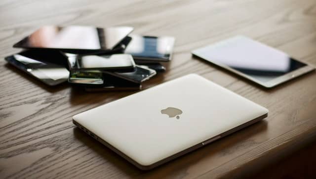 Un ordinateur portable à côté d’une collection d’appareils mobiles